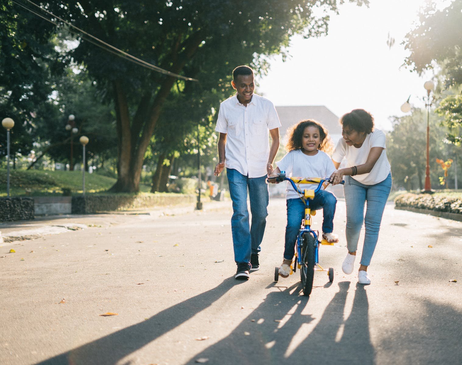 Man and Wife Teaching Their Child How to Ride Bicycle